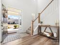 Bright foyer with wood floors, staircase, and a view of the neighborhood through the front door at 5532 Muckross Ln, Fort Mill, SC 29707