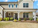 Charming home featuring well-manicured landscaping, a cozy covered porch, and inviting front door with floral accents at 5532 Muckross Ln, Fort Mill, SC 29707