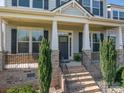 Home's covered front porch with stone pillars and black railing, perfect for relaxing outdoors at 6352 Willow Farm Dr, Denver, NC 28037