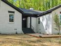 Exterior front entrance features black door, white painted brick, and concrete stairs with metal railings at 6724 Brushwood Dr, Charlotte, NC 28262