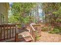 Wooden deck with seating and grill, surrounded by mature trees and greenery at 7536 Bimini Ct, Sherrills Ford, NC 28673