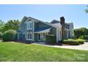 Charming two-story home with manicured lawn, lush greenery, and a welcoming entrance, framed by an American flag at 8257 Legare Ct, Charlotte, NC 28210