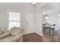 Inviting home entrance featuring a chair, light hardwood floors, and a view into the dining area at 8257 Legare Ct, Charlotte, NC 28210
