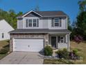 Charming two-story home with stone accents, vinyl siding, a white garage door, well-manicured front yard and wreath at 9112 Avery Meadows Dr, Charlotte, NC 28216
