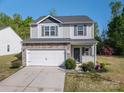 Charming two-story home with stone accents, vinyl siding, a white garage door, well-manicured front yard and wreath at 9112 Avery Meadows Dr, Charlotte, NC 28216