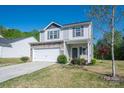 Charming two-story home with stone accents, vinyl siding, a white garage door, well-manicured front yard and wreath at 9112 Avery Meadows Dr, Charlotte, NC 28216