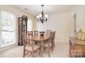 Traditional dining room showcasing a wooden table, chairs, grandfather clock, and a chandelier at 9208 Plashet Ln, Mint Hill, NC 28227