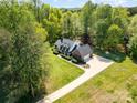 Beautiful aerial view of home with spacious yard and long driveway, surrounded by lush trees and greenery at 127 Fantasy Ln, Mooresville, NC 28117