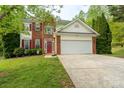 Charming two-story home with a brick and siding exterior, a red door, and well-manicured lawn at 13228 Crooked Pine Ct, Charlotte, NC 28215