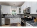 Well-lit kitchen features granite counters, stainless steel appliances, and white cabinets at 13228 Crooked Pine Ct, Charlotte, NC 28215