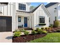 Close-up of front door with blue accent, tidy landscaping, and inviting front porch at 14013 Pinoli Pine Cir, Huntersville, NC 28078