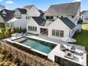 Backyard features a modern pool with lounge area, outdoor seating and a fire pit at 14013 Pinoli Pine Cir, Huntersville, NC 28078