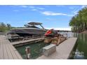 View of a private dock with a sleek boat and jet ski, offering direct access to the water and recreational fun at 1717 Brawley School Rd, Mooresville, NC 28117