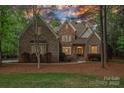 Charming two-story home with stone and brick facade, complemented by manicured landscaping and mature trees at 1717 Brawley School Rd, Mooresville, NC 28117