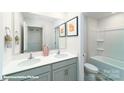 Full bathroom with double vanity, framed mirror, tile flooring, and a separated tub with shower combination at 1989 10Th Se St, Hickory, NC 28602