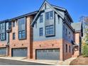 Exterior of two-story townhomes featuring a mix of blue siding and brick, highlighted by well-placed windows and gray garages at 2027 Thurmond Pl, Charlotte, NC 28205