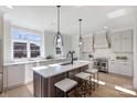 Bright kitchen featuring a quartz island with seating, stainless steel appliances, and modern pendant lighting at 2027 Thurmond Pl, Charlotte, NC 28205