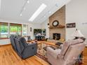 Cozy living room featuring a brick fireplace, skylights, and comfortable seating at 2251 Old Applewood Ln # 9, Iron Station, NC 28080