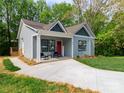 Charming home featuring a well-manicured lawn, inviting front porch, and gray wood siding at 2302 Jordi Way, Charlotte, NC 28213