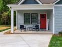 Inviting front porch featuring a seating area and a vibrant red front door at 2302 Jordi Way, Charlotte, NC 28213