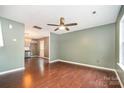 Spacious living room with hardwood floors, ceiling fan, and natural light with an eat-in kitchen in the background at 248 Pangle Dr, Charlotte, NC 28217