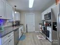 Well-lit kitchen with stainless steel appliances, granite countertops, and white cabinetry at 252 S Potter Rd, Lancaster, SC 29720
