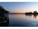 A serene lake view with a colorful sunset sky reflecting on the calm water's surface at 264 Fairway Shores Rd, Mount Gilead, NC 27306