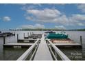 Picturesque dock featuring multiple boat slips on a tranquil lake with clear blue skies at 300 Yacht Rd, Mooresville, NC 28117