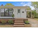 Close up of white brick home with a brick porch and stairs leading to the main entrance and black mailbox at 3108 Anne St, Charlotte, NC 28205