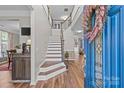 Inviting foyer with wood floors, staircase, blue front door with leaded glass, and charming decorative touches at 3831 Robeson Creek Dr, Charlotte, NC 28270