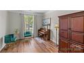 Cozy living room featuring hardwood floors, piano, natural light, and elegant decor creating a welcoming space at 3831 Robeson Creek Dr, Charlotte, NC 28270