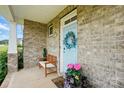 Close-up of a charming light blue front door with wreath, bench seating and colorful potted plants at 4040 Lauren Elizabeth Dr, Rock Hill, SC 29732
