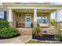 Inviting front porch with bench, swing, brick accents, and a light blue front door with a wreath at 4040 Lauren Elizabeth Dr, Rock Hill, SC 29732