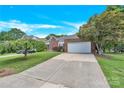 Brick home with a lush front lawn and a long driveway leading to an attached garage at 4155 Guilford Nw Ct, Concord, NC 28027