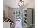 Welcoming foyer with open door, wood stairs, built-in shelves, and natural light streaming in at 4313 Sudbury Rd, Charlotte, NC 28205