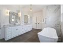 Modern bathroom featuring double vanity, marble accents, soaking tub, and tiled floors at 5010 Ohm Ln, Charlotte, NC 28270