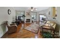 Inviting living room featuring hardwood floors, a fireplace, and a ceiling fan at 5404 Dunedin Ln, Charlotte, NC 28270