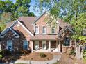Charming brick home with a welcoming front porch, beautiful landscaping, and mature trees providing ample shade at 551 Hemmings Nw Pl, Concord, NC 28027