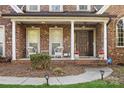 Inviting front porch with classic columns, comfortable seating, and a well-maintained entrance for curb appeal at 551 Hemmings Nw Pl, Concord, NC 28027