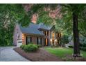 Attractive two-story brick home with attached garage, lush landscaping, and warm lighting, showcasing curb appeal at 6017 Summerston Pl, Charlotte, NC 28277