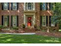 Charming brick facade with a welcoming red front door and manicured landscaping at 6017 Summerston Pl, Charlotte, NC 28277