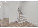 Hallway features wood-look floors, white walls, and a staircase leading to the upper level, with a glimpse of the front door at 655 District Ct, Fort Mill, SC 29708
