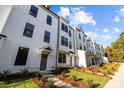 Modern townhomes with white exteriors, green lawns and tasteful landscaping on a bright day at 657 District Ct, Fort Mill, SC 29708