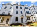 New construction townhome showcasing modern white facade, dark framed windows and manicured landscaping at 657 District Ct, Fort Mill, SC 29708