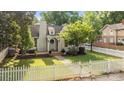 Charming home with brick walkway, white picket fence, well-manicured lawn, and mature landscaping under a bright blue sky at 700 Oakland Ave, Charlotte, NC 28204