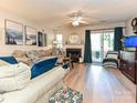 Spacious living room featuring a fireplace, plush sofa, and access to the outdoor deck at 9305 Four Mile Creek Rd, Charlotte, NC 28277