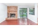 Living room showcasing a brick fireplace, sliding glass doors, and hardwood flooring at 10967 Harrowfield Rd, Charlotte, NC 28226
