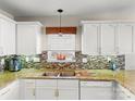 Well-lit kitchen with granite countertops, white cabinetry, tiled backsplash, and stainless steel appliances at 115 Keswick Ln, Mooresville, NC 28117