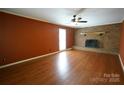 Spacious living room with hardwood floors, brick fireplace, ceiling fan and natural light from window at 1174 Orchard Dr, Fort Mill, SC 29715