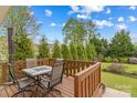 Enjoy outdoor dining on the wooden deck, surrounded by a lush green lawn and mature trees at 12746 Bravington Rd, Huntersville, NC 28078